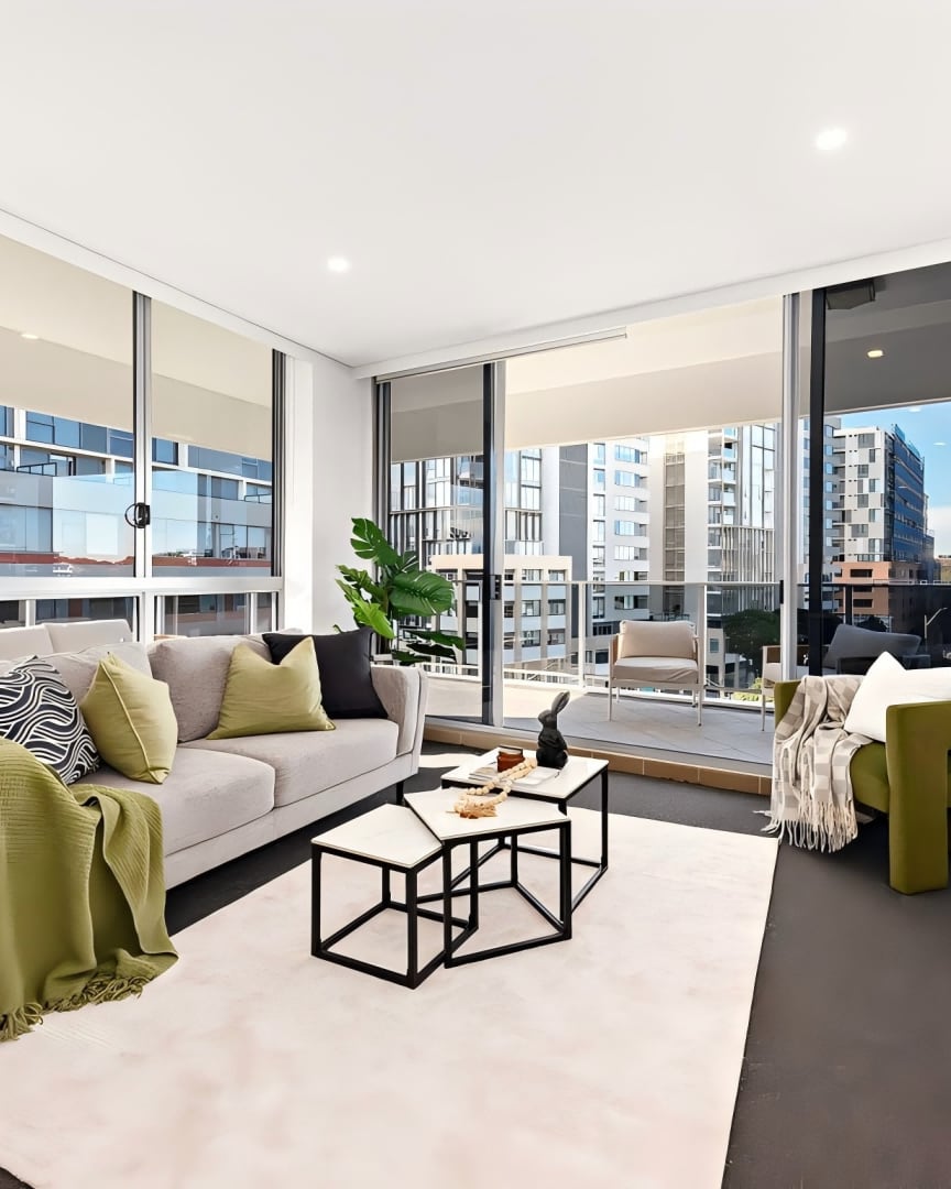 Rosebery apartment living room with a grey sofa, olive throw and balcony views