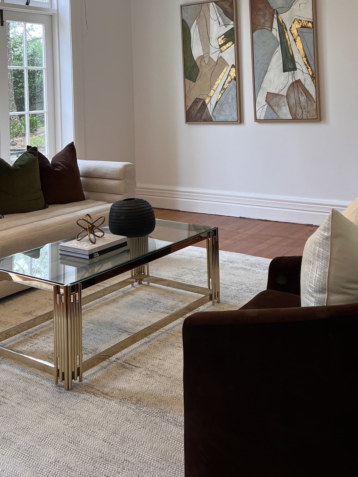 Glass and brass coffee table with a channelled sofa and cushions